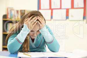 Stressed Schoolgirl Studying In Classroom