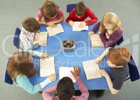 Overhead View Of Schoolchildren Working Together At Desk