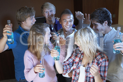 Group Of Teenage Friends Dancing And Drinking Alcohol