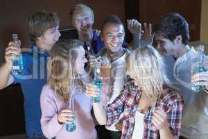 Group Of Teenage Friends Dancing And Drinking Alcohol