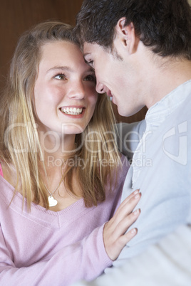 Romantic Teenage Couple Sitting On Sofa At Home Together