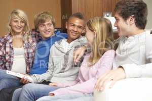 Group Of Teenage Friends Sitting On Sofa At Home Watching TV