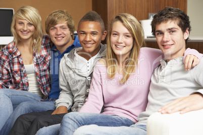 Group Of Teenage Friends Sitting On Sofa At Home