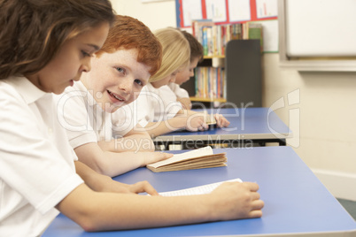 Group Of Children Reading Books In Classroom