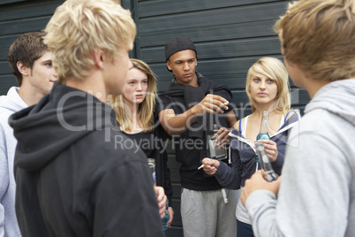 Group Of Threatening Teenagers Hanging Out Together Outside Drin