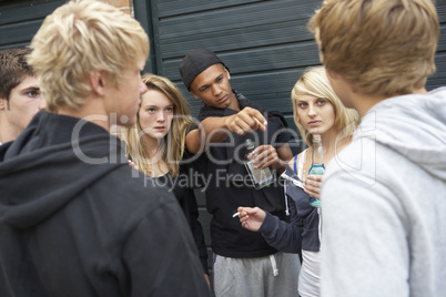 Group Of Threatening Teenagers Hanging Out Together Outside Drin