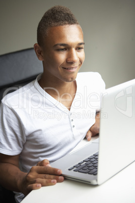 Teenage Boy Using Laptop At Home