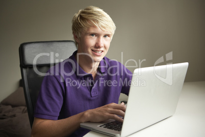 Teenage Boy Using Laptop At Home