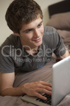 Teenage Boy Using Laptop At Home