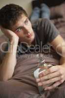 Teenage Boy Lying  In Bedroom Drinking