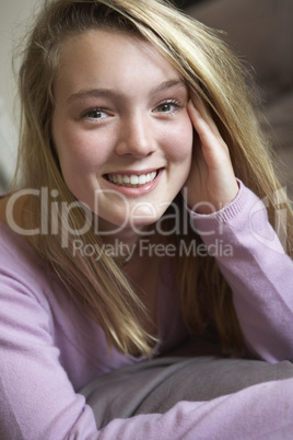 Happy Teenage Girl Sitting In Bedroom