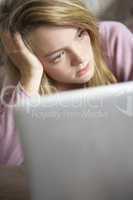 Unhappy Teenage Girl Using Laptop At Home