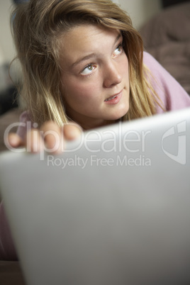 Guilty Looking Teenage Girl Using Laptop At Home