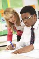 Teenage Student Working In Classroom With Teacher