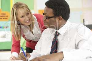 Teenage Student Working In Classroom With Teacher