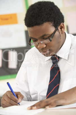 Male Teenage Student Studying In Classroom