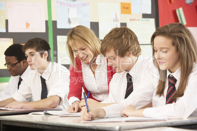 Teenage Students Studying In Classroom With Teacher