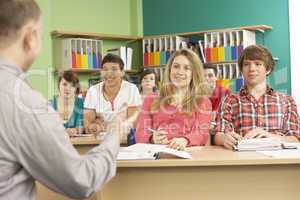 Teenage Students Studying In Classroom With Tutor