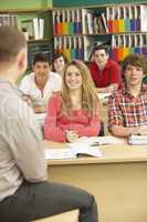 Teenage Students Studying In Classroom With Tutor