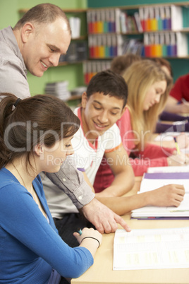 Teenage Students Studying In Classroom With Tutor