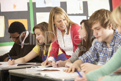 Teenage Students Studying In Classroom With Teacher