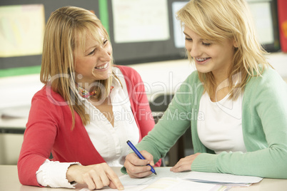 Female Teenage Student Studying In Classroom With Teacher