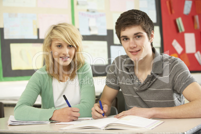 Male And Female Teenage Students Studying In Classroom