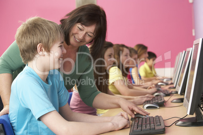 Teenage Students In IT Class Using Computers In Classroom With T