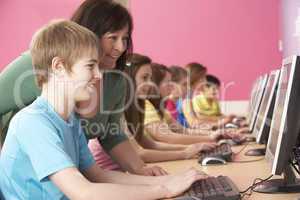 Teenage Students In IT Class Using Computers In Classroom With T