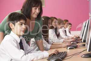 Teenage Students In IT Class Using Computers In Classroom With T