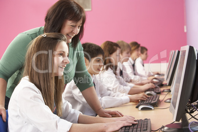 Teenage Students In IT Class Using Computers In Classroom With T