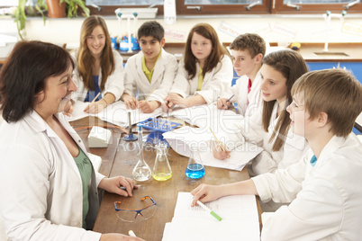 Group Of Teenage Students In Science Class With Tutor