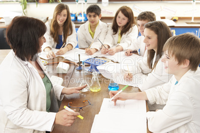 Group Of Teenage Students In Science Class With Tutor