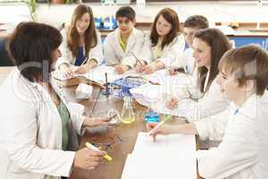 Group Of Teenage Students In Science Class With Tutor