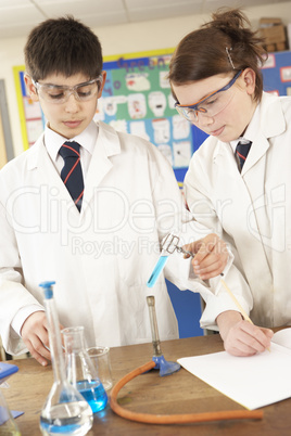 Male And Female Teenage Student In Science Class With Experiment