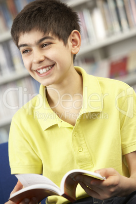 Male Teenage Student In Library Reading Book