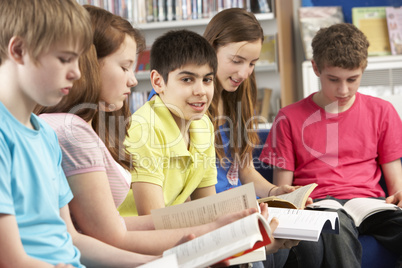 Teenage Students In Library Reading Books