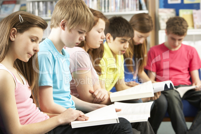 Teenage Students In Library Reading Books