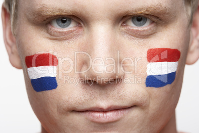 Young Male Sports Fan With Dutch Flag Painted On Face