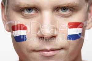 Young Male Sports Fan With Dutch Flag Painted On Face