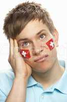 Disappointed Young Male Sports Fan With Swiss Flag Painted On Fa