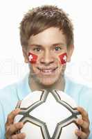 Young Male Football Fan With Swiss Flag Painted On Face