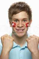 Young Male Sports Fan With Swiss Flag Painted On Face