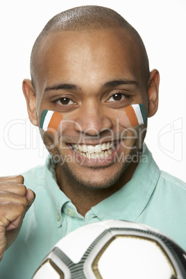 Young Male Football Fan With Ivory Coast Flag Painted On Face