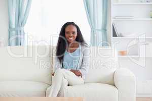 Smiling woman sitting on sofa