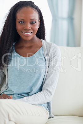 Close up of smiling woman sitting on sofa Close up of smiling woman sitting on sofa