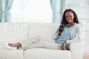 Woman sitting with legs on her sofa