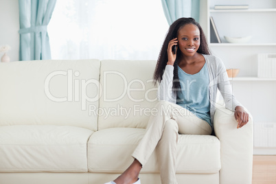 Woman with mobile phone on sofa