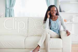Woman with mobile phone on sofa