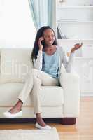 Woman talking on the phone while sitting on the couch